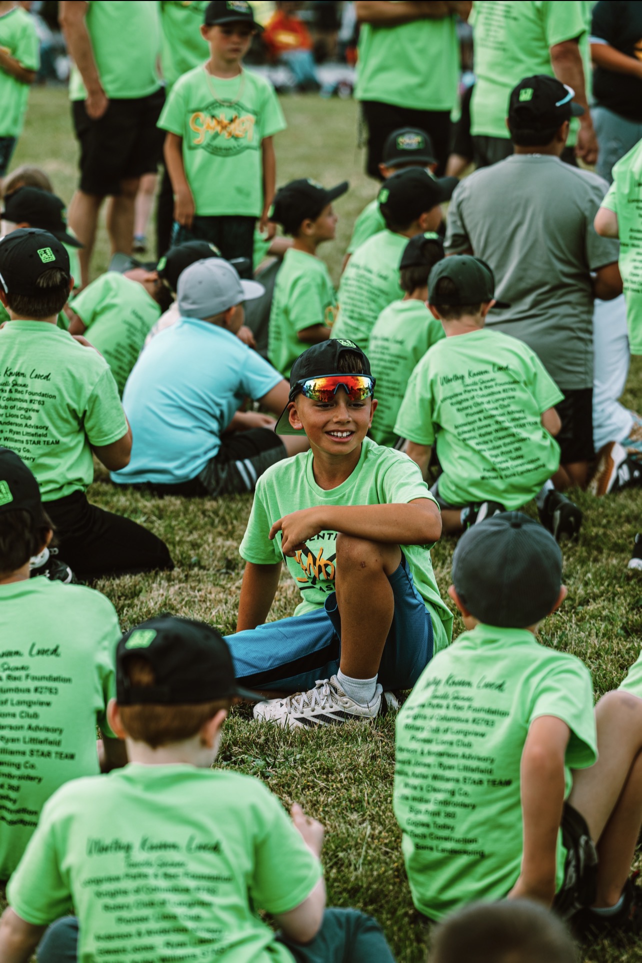 Kids gathered together in bright green program shirts